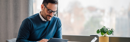 Man at desk with tablet and laptop
